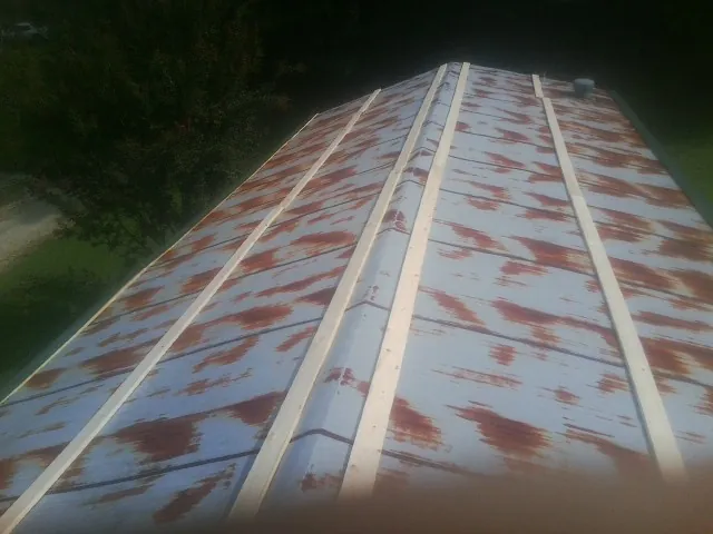 Rusted metal roof panels with new wood purlins before replacement — Storm Damage Roof Repair in Abington by Roofing Brothers