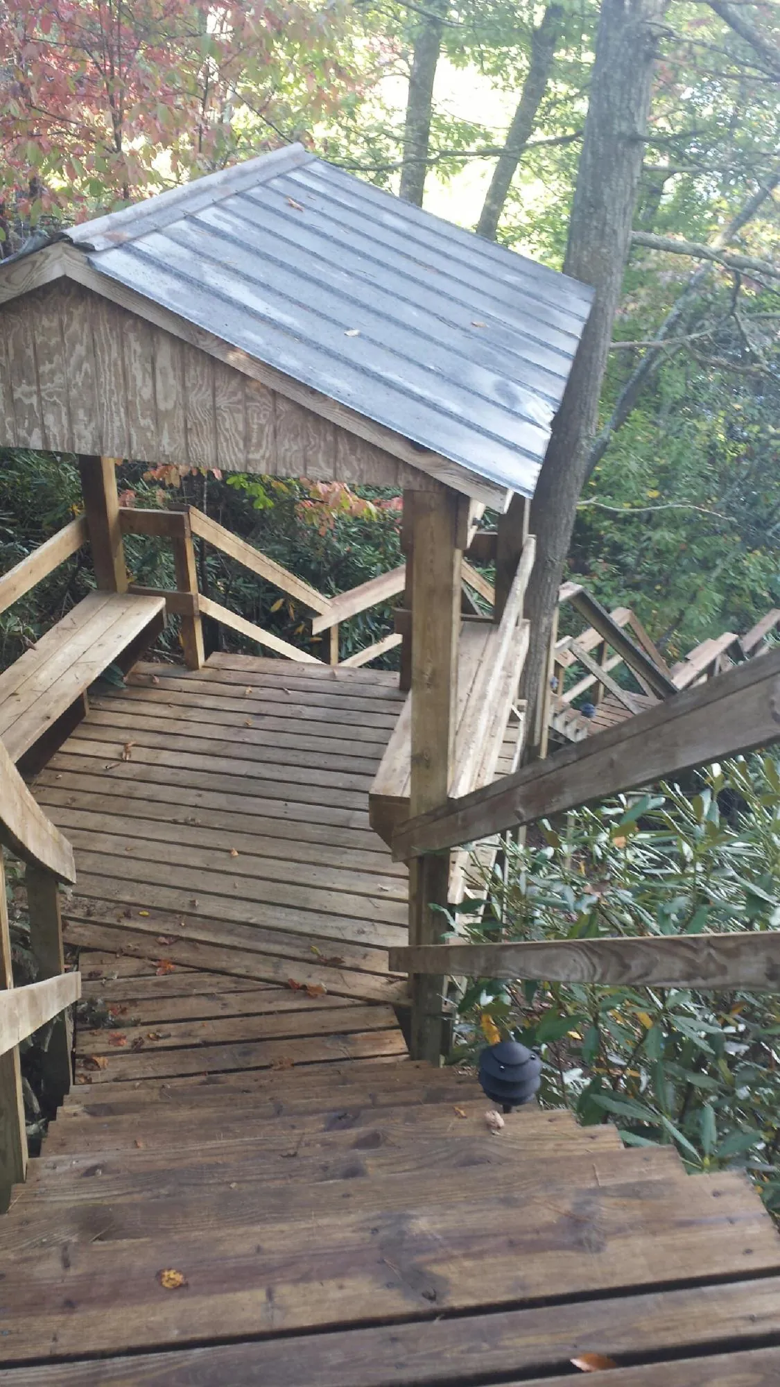 Metal roofed shelter over wooden steps on a wooded walkway — Skylight Repair & Installation work by our crew in Abington